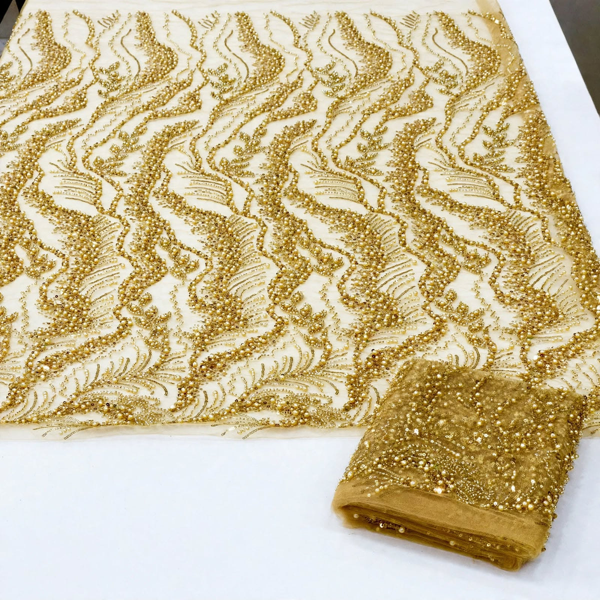 Tissu perlage doré à feuillages ondulés, au mètre