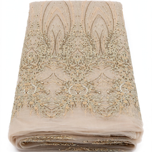 Tissu perlage beige champagne plié à motifs ornementaux dorés, perles et sequins, sur fond blanc.